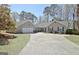 Exterior home view showcasing a well-maintained landscape, long driveway, attached garage, and inviting curb appeal at 200 Doe Run, Peachtree City, GA 30269