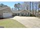 Charming home exterior with a wide driveway, a vibrant blue front door, and attached two-car garage at 200 Doe Run, Peachtree City, GA 30269
