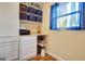Bright home office with blue curtains, shelving, desk space, and white cabinets for ample storage at 200 Doe Run, Peachtree City, GA 30269