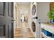 Well-lit laundry room with stacked washer and dryer and convenient hallway access at 200 Doe Run, Peachtree City, GA 30269