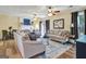 Open concept living room with wood floors, ample seating, and a view of the fireplace and dining area at 200 Doe Run, Peachtree City, GA 30269