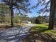 View of a quaint home with a gravel driveway and lush trees framing the property at 4064 Post Rd, Winston, GA 30187