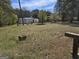 Home with metal roof and gravel driveway on a vast lot with green grass and lush trees at 4064 Post Rd, Winston, GA 30187