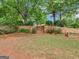 Landscaped backyard with retaining walls, flowerbeds, wooden stairs, and lush green lawn at 1103 Wilder Ct, Mcdonough, GA 30252