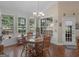 Bright dining room featuring hardwood floors, wainscotting, a chandelier, and a view of the backyard at 1103 Wilder Ct, Mcdonough, GA 30252