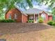 Charming single-story brick home featuring a well-manicured lawn and inviting front porch with elegant white columns at 1103 Wilder Ct, Mcdonough, GA 30252