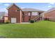 Brick home featuring a spacious backyard with lush green grass and a covered patio at 375 Oakpark Ter, Mcdonough, GA 30253