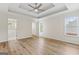Spacious bedroom with tray ceiling, fan, and wood-look floors at 375 Oakpark Ter, Mcdonough, GA 30253