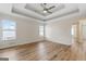 Large bedroom with a tray ceiling, ceiling fan, and wood-look floors at 375 Oakpark Ter, Mcdonough, GA 30253