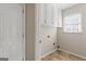 Functional laundry room with white cabinets, tile floor, and a window for natural light at 375 Oakpark Ter, Mcdonough, GA 30253
