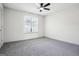 Spacious bedroom with neutral walls, carpeted floors, ceiling fan and a bright window at 2047 Charter Ln, Lithonia, GA 30058