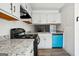 Modern kitchen boasts white cabinets, granite countertops, a black range, and a bright blue dishwasher at 2047 Charter Ln, Lithonia, GA 30058