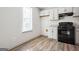 Well-lit kitchenette offers laminate flooring, white cabinets, granite countertops, and a black range at 2047 Charter Ln, Lithonia, GA 30058