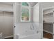 Bright bathroom featuring a garden tub beneath a window, and walk-in closet at 1291 Interlaken Pass, Jonesboro, GA 30238