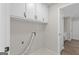 Neat laundry room includes upper cabinets for storage and tile flooring at 1291 Interlaken Pass, Jonesboro, GA 30238
