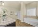 Bright bathroom featuring a soaking tub, walk-in shower, wood-look floors, and vanity with granite counters at 2385 Aukerman Trce # 80, Hampton, GA 30228