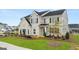 New two-story home featuring a brick facade, green lawn, and a well-manicured landscape at 1813 Quaker St, Hampton, GA 30228