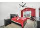 Stylish bedroom featuring bright red accent wall, ceiling fan and a large window at 3709 Royer Ln # 23, Hampton, GA 30228
