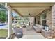 Covered patio with brick accents, wicker furniture, ceiling fan, and view of outdoor kitchen and pool at 3709 Royer Ln # 23, Hampton, GA 30228