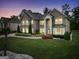 Evening view of a stately two-story brick home showcasing manicured landscaping and elegant architectural details at 3709 Royer Ln # 23, Hampton, GA 30228