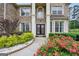 Close-up of elegant double doors with decorative wreath framed by columns and lush flowerbeds at 3709 Royer Ln # 23, Hampton, GA 30228