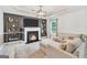 Inviting living room featuring a cozy fireplace, TV, and built-in shelving for storage and decor at 3709 Royer Ln # 23, Hampton, GA 30228