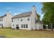 A view of the home's backyard and neighboring building, all set amongst well-manicured grass at 4376 Grant Forest Cir, Ellenwood, GA 30294