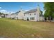 Exterior shot of the backyard with well-manicured grass and a view of neighboring buildings at 4376 Grant Forest Cir, Ellenwood, GA 30294