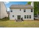 Two-story home featuring a backyard with a grill, patio set, and sliding glass doors at 4376 Grant Forest Cir, Ellenwood, GA 30294
