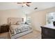 Bright bedroom featuring a tufted headboard, ceiling fan, and neutral-toned walls for a calming ambiance at 4376 Grant Forest Cir, Ellenwood, GA 30294