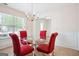 Dining room with glass table, chandelier, and red upholstered chairs at 4376 Grant Forest Cir, Ellenwood, GA 30294