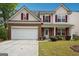 Charming two-story home featuring a brick facade, red shutters, and a two-car garage at 4376 Grant Forest Cir, Ellenwood, GA 30294