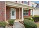 Inviting front porch with brick facade, white columns, and lush green landscaping at 4376 Grant Forest Cir, Ellenwood, GA 30294