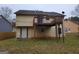 Backyard view with a wooden deck and an older-style siding on the house, set in a grassy, tree-filled area at 1119 Oakwood Manor Ct, Decatur, GA 30032