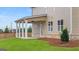 Spacious backyard with a covered patio supported by white columns and green lawn at 1808 Quaker St, Hampton, GA 30228