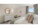 Bright bedroom featuring a white bed, stylish dresser, a round gold mirror and zebra-patterned curtains at 1808 Quaker St, Hampton, GA 30228
