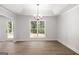 Bright dining room featuring wood flooring, a modern light fixture, and a large window with a backyard view at 3269 Broadnax Mill Rd # 1, Loganville, GA 30052