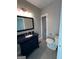 Bathroom with tile floors, dark vanity, toilet, and light fixture at 59 S Old Hwy 27, Roopville, GA 30170