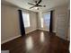 Spacious bedroom featuring hardwood floors, a ceiling fan, and natural light from two windows at 59 S Old Hwy 27, Roopville, GA 30170