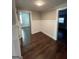 Well-lit living room with hardwood floors and white wainscoting, offering a view into adjacent rooms at 59 S Old Hwy 27, Roopville, GA 30170