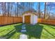 Backyard shed is clean and well kept, nestled within a manicured lawn and wood fence at 5109 Dogwood Hills Dr, Sugar Hill, GA 30518