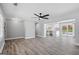 Spacious open floor plan featuring modern gray wood flooring and a ceiling fan at 5109 Dogwood Hills Dr, Sugar Hill, GA 30518
