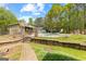 Landscaped backyard with a stone retaining wall and path leading to a pool at 130 Ashley Trace Dr, Locust Grove, GA 30248