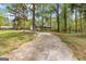 View of driveway approaching home with large trees surrounding the perimeter of the property at 130 Ashley Trace Dr, Locust Grove, GA 30248