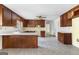 Open kitchen featuring wood cabinetry, tile floors, and white countertops, bathed in natural light from a window at 130 Ashley Trace Dr, Locust Grove, GA 30248