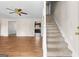 Open floor plan living room, features staircase, wood floors, kitchen view and neutral color palette at 130 Ashley Trace Dr, Locust Grove, GA 30248