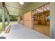 Covered concrete barn interior with stalls leading to a manicured fenced pasture at 290 Weldon Rd, Fayetteville, GA 30215