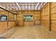 Well-lit stall in barn featuring wood interior, hay feeder, and window to the outside at 290 Weldon Rd, Fayetteville, GA 30215