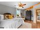 Comfortable bedroom with hardwood floors, a queen bed with decorative pillows, soft lighting, and rustic wood beam accents at 290 Weldon Rd, Fayetteville, GA 30215