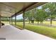 Inviting covered porch with concrete flooring that overlooks a fenced green pasture at 290 Weldon Rd, Fayetteville, GA 30215